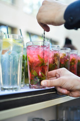 hands preparing mojito cocktail