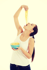 Woman eating pasta from a bowl.