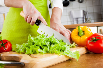 Obraz na płótnie Canvas Woman's hands cutting vegetables