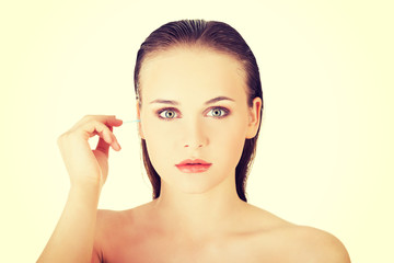 Woman cleans her ear