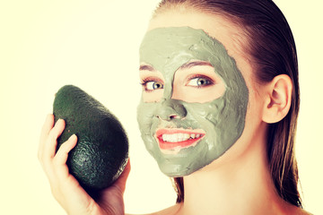 Spa woman in facial mask and avocado