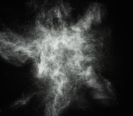 White powder exploding isolated on black