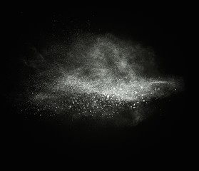 White powder exploding isolated on black