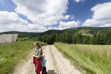 Woman with child hikes mountain patch, Gorce Mountains, Poland