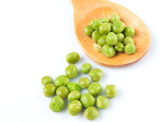 Green peas on wooden spoon over white background