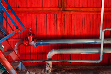 Old industrial factory background. Red wooden wall with pipes. © kotina