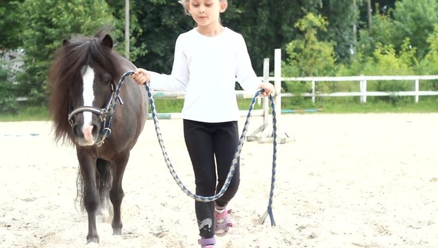 girl walking with a pony on-site horseback riding