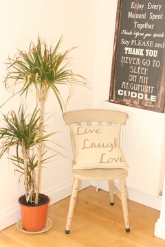 A Retro Style Chair With A Cushion Saying Live, Laugh, Love