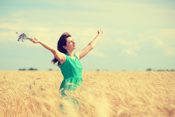 Woman enjoying the sun on wheat field