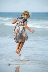 Kleines Mädchen springt am Strand