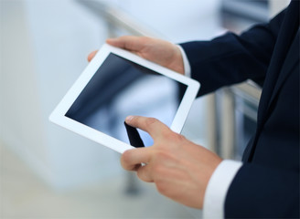 Midsection of businessman using digital tablet in office