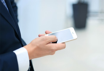 Close up of a business man using mobile smart phone