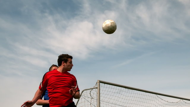 Football players jumping up and tackling for the ball