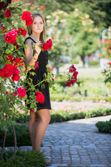 Portrait of the beautiful girl in rose garden