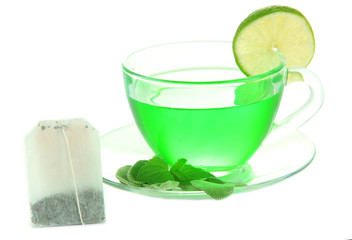 Transparent cup of green tea and teabag isolated on white