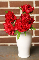 Beautiful pink peonies on bricks wall background