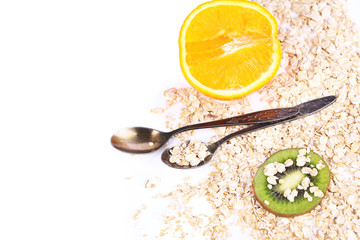 Kiwi fruit and orange with oatmeal and vintage spoons isolated