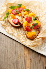 Tasty bruschetta with tomatoes, on old wooden table