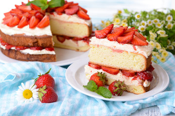 Delicious biscuit cake with strawberries on table close-up