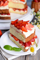 Delicious biscuit cake with strawberries on table close-up