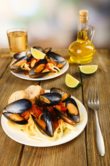 Tasty noodles with mussels on table, close up