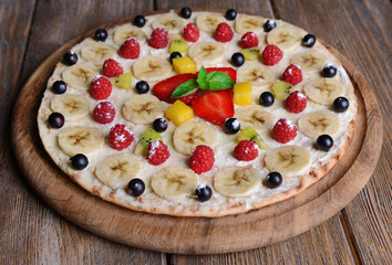 Sweet pizza with fruits on table close-up