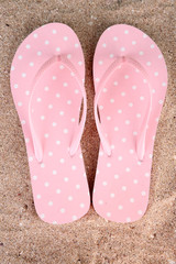 Color flip-flops on sand background