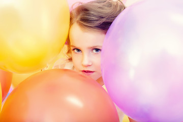 Fototapeta na wymiar Cute girl posing with balloons, close-up
