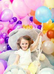 Fototapeta na wymiar Cheerful girl posing holding bunch of balloons