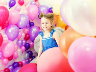 Fototapeta na wymiar Adorable girl posing among colorful balloons