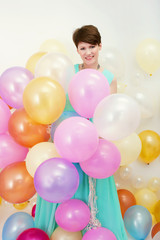 Pretty woman holds big bunch of colorful balloons