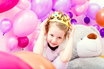 Fototapeta na wymiar Portrait of funny little girl trying on crown