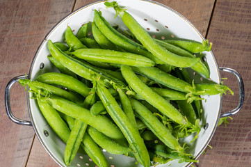 Fresh peas in a white colander