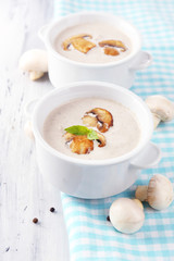 Mushroom soup in white pots, on napkin,  on wooden background