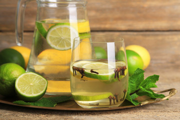 Fresh summer drink with lime and cloves in glass and jug,