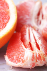 Ripe grapefruits on cutting board, on wooden background