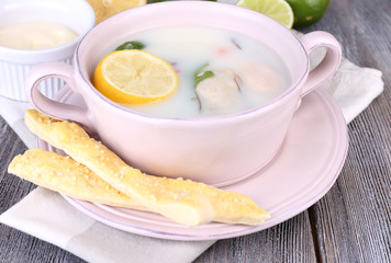 Tasty soup with oysters on wooden table