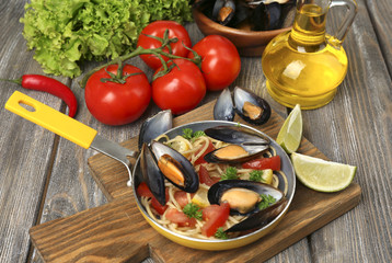 Traditional noodles with mussels on table, close up