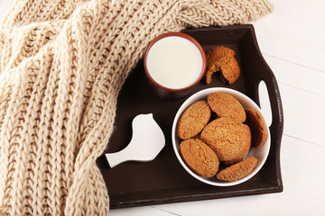 Milk and cookies on tray on table