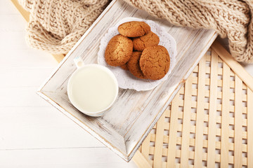 Milk and cookies on tray on table