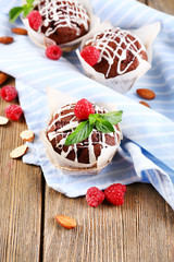 Tasty cupcakes with raspberries on table close-up