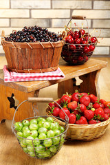 Fresh berries in basket on wall background