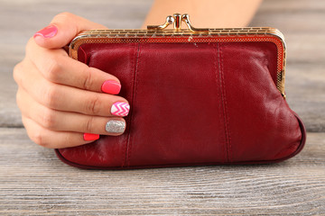 Female hand with stylish colorful nails holding little bag,