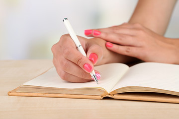 Female hand with stylish colorful nails holding pen,