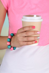 Woman with stylish colorful nails holding mug, close-up,