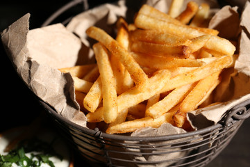 Tasty french fries in metal basket