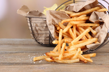 Tasty french fries and potato chips in metal baskets