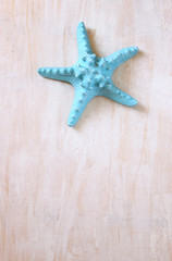 Fototapeta na wymiar blue starfish over wooden textured board 