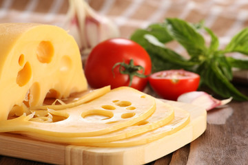 Cheese on a cutting board, basil, tomato