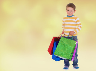 little boy in colorful bags goes to the store.